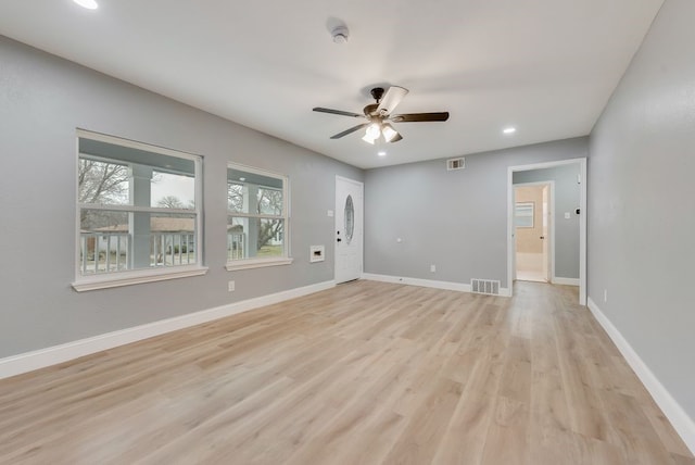 spare room with light wood-type flooring, baseboards, visible vents, and ceiling fan