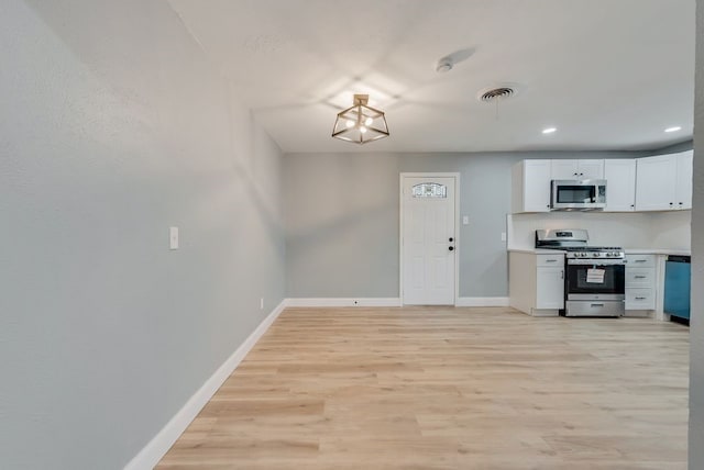 kitchen featuring light countertops, visible vents, light wood-style flooring, appliances with stainless steel finishes, and baseboards