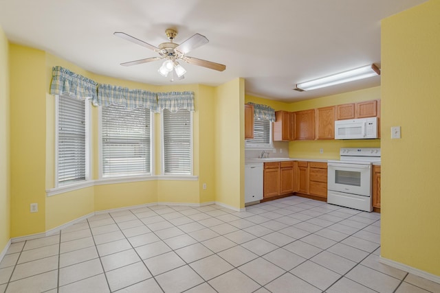 kitchen with white appliances, light tile patterned floors, a ceiling fan, light countertops, and a sink