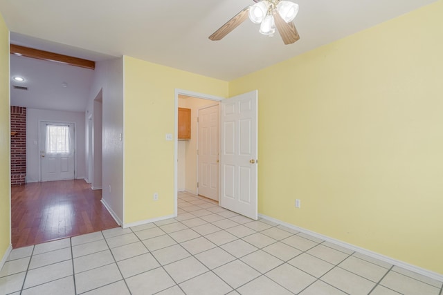 spare room with light tile patterned floors, ceiling fan, visible vents, and baseboards