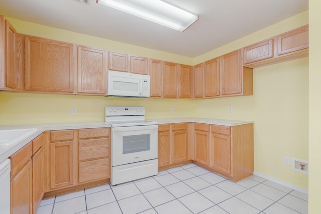 kitchen with light countertops, white appliances, light tile patterned flooring, and light brown cabinetry