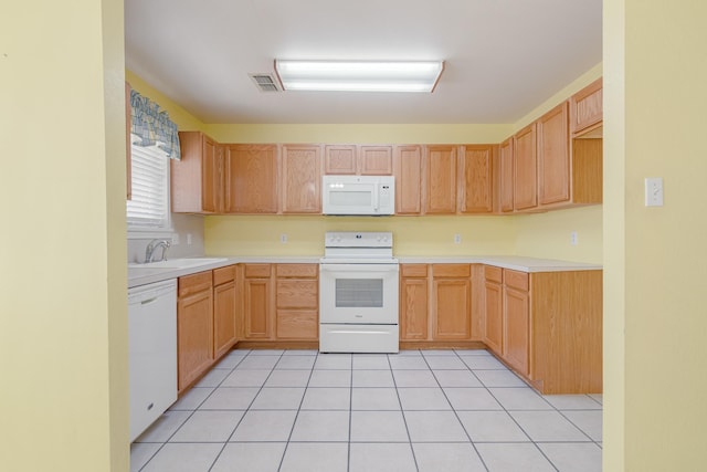 kitchen featuring light tile patterned floors, white appliances, a sink, visible vents, and light countertops