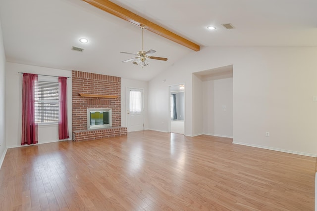 unfurnished living room with vaulted ceiling with beams, light wood-style flooring, a fireplace, and visible vents