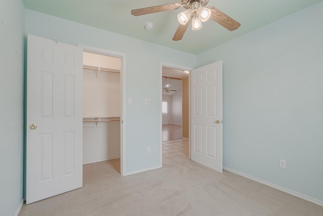 unfurnished bedroom featuring ceiling fan, carpet floors, baseboards, a spacious closet, and a closet