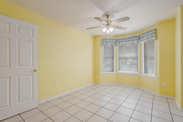 spare room with baseboards, a ceiling fan, and light tile patterned flooring