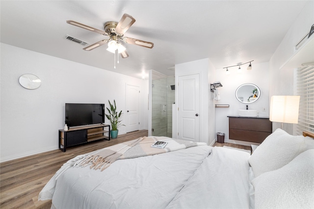 bedroom featuring visible vents, ceiling fan, baseboards, and wood finished floors