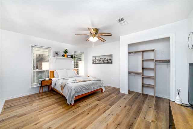 bedroom with visible vents, baseboards, light wood-style floors, and a ceiling fan