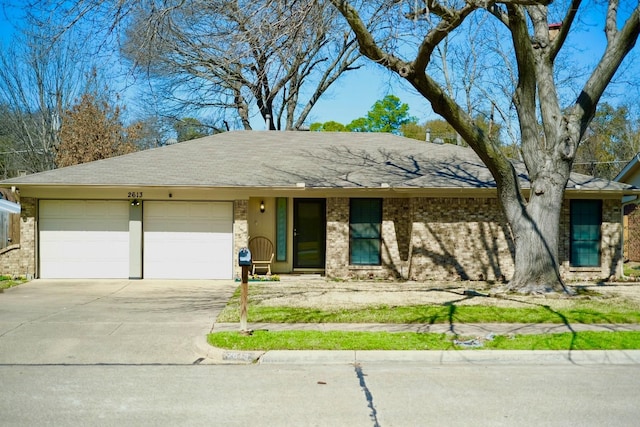 view of front facade with brick siding, driveway, an attached garage, and roof with shingles