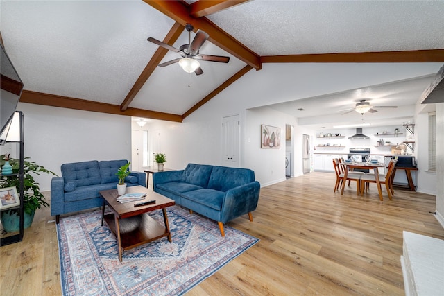 living room featuring baseboards, ceiling fan, lofted ceiling with beams, light wood-style floors, and a textured ceiling