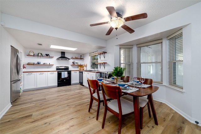 dining area with light wood-type flooring, visible vents, a ceiling fan, a textured ceiling, and baseboards