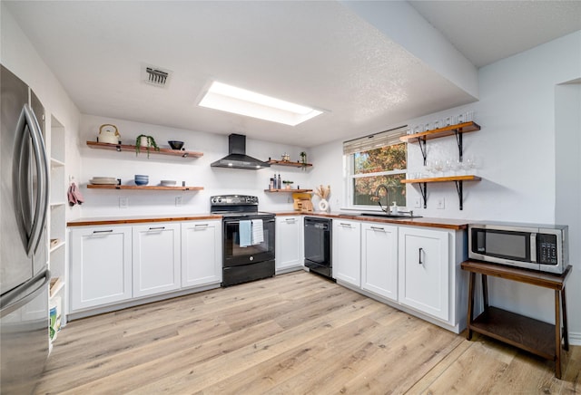 kitchen with black appliances, open shelves, a sink, wall chimney exhaust hood, and wooden counters