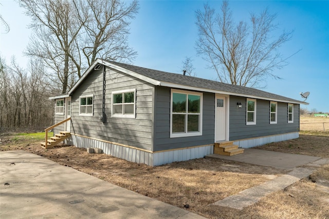 manufactured / mobile home with entry steps and roof with shingles