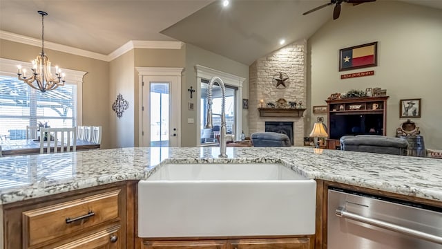 kitchen with light stone counters, a healthy amount of sunlight, a fireplace, and a sink