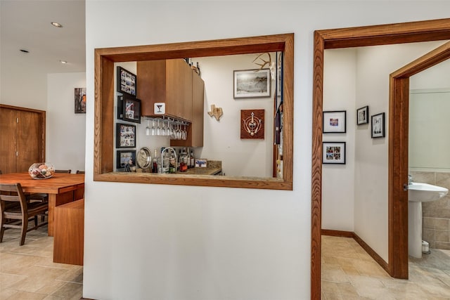 hall featuring a sink and baseboards