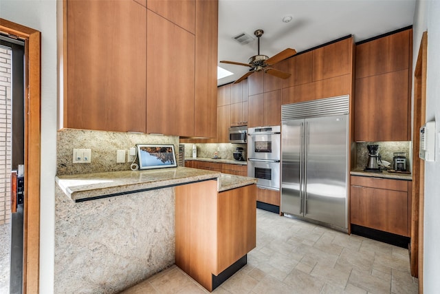 kitchen featuring ceiling fan, stainless steel appliances, tasteful backsplash, and brown cabinetry