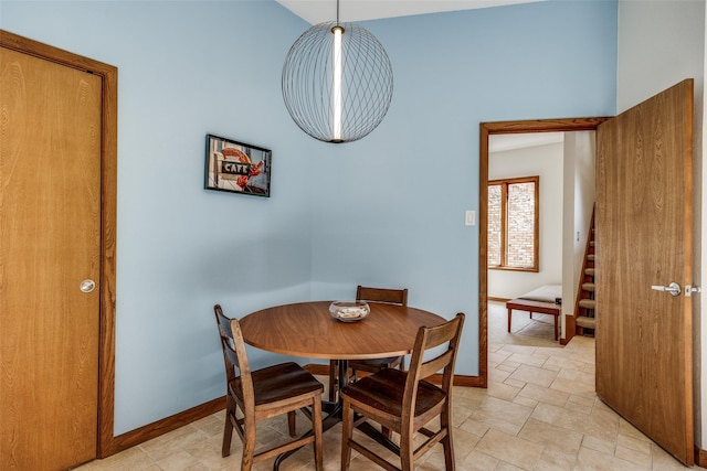 dining area with stairs, stone finish flooring, and baseboards