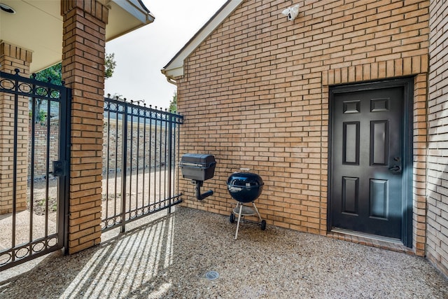 property entrance featuring a gate and brick siding