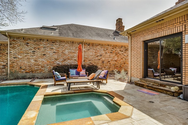 outdoor pool with a patio and an in ground hot tub