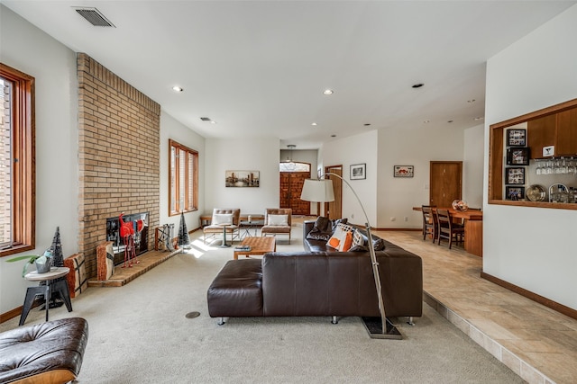 living area with light colored carpet, a brick fireplace, visible vents, and recessed lighting