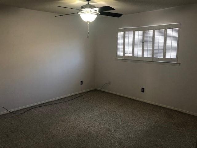 empty room with a ceiling fan and baseboards