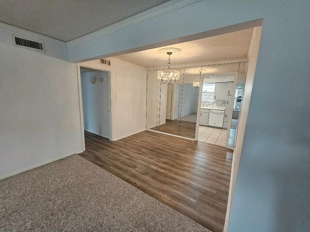 5825 Birchbrook Dr Unit 106, Dallas, TX 75206 - unfurnished room featuring a chandelier, crown molding, wood finished floors, and baseboards