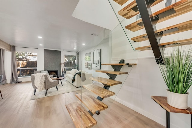 living area with a fireplace, recessed lighting, visible vents, wood finished floors, and baseboards