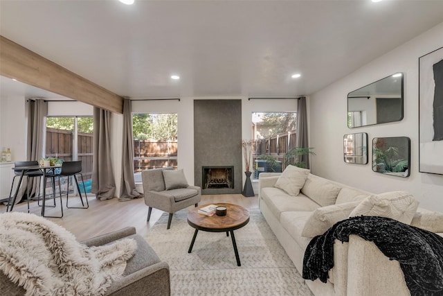 living room with a large fireplace, plenty of natural light, wood finished floors, and recessed lighting