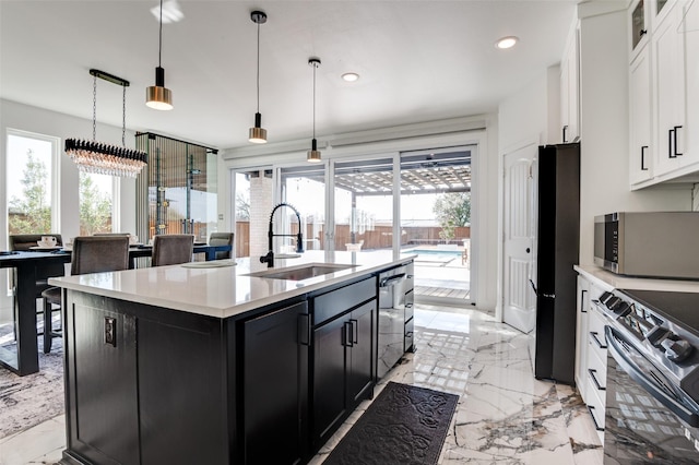 kitchen with a wealth of natural light, dark cabinets, marble finish floor, stainless steel appliances, and a sink