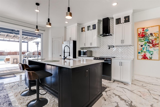 kitchen featuring wall chimney exhaust hood, marble finish floor, stainless steel appliances, light countertops, and a sink