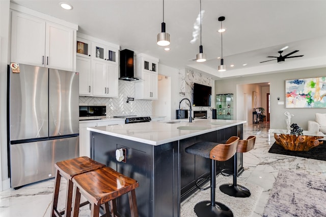 kitchen with marble finish floor, wall chimney exhaust hood, appliances with stainless steel finishes, and a sink