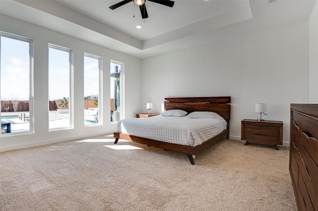 bedroom with ceiling fan, recessed lighting, light colored carpet, baseboards, and a raised ceiling