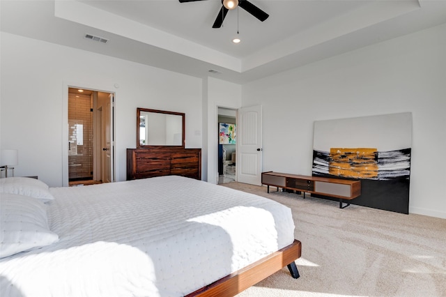 carpeted bedroom with ensuite bathroom, a tray ceiling, visible vents, and recessed lighting