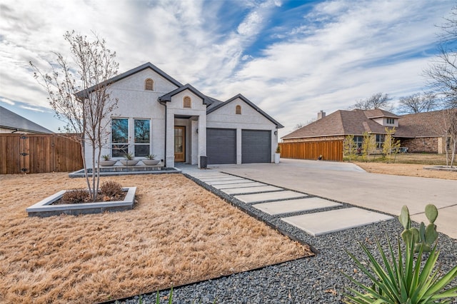 view of front of house with a garage, brick siding, fence, and driveway