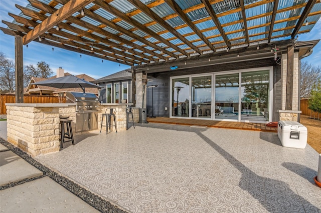 view of patio / terrace with a grill, fence, outdoor dry bar, and a pergola