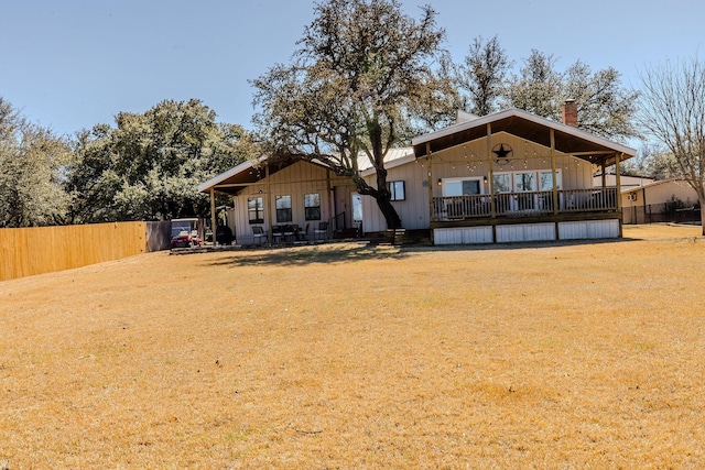 rear view of property with a yard and fence