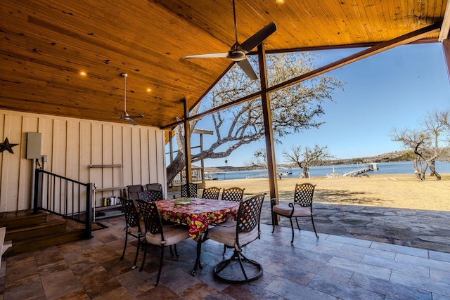 view of patio / terrace featuring stairs, outdoor dining area, a ceiling fan, and a water view