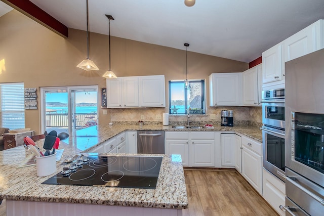 kitchen with a sink, lofted ceiling with beams, white cabinetry, and stainless steel appliances