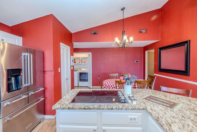 kitchen with visible vents, white cabinets, a notable chandelier, high end fridge, and black electric cooktop