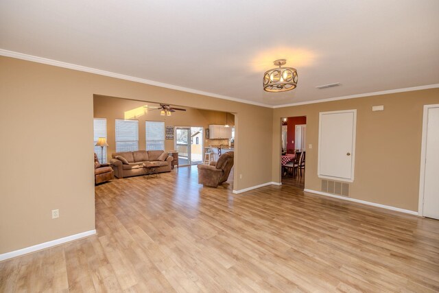 unfurnished living room featuring crown molding, light wood-style flooring, and baseboards