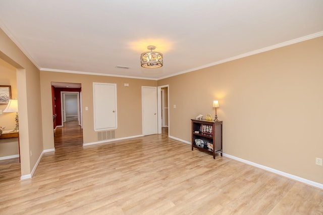 unfurnished room featuring light wood-type flooring, visible vents, an inviting chandelier, crown molding, and baseboards