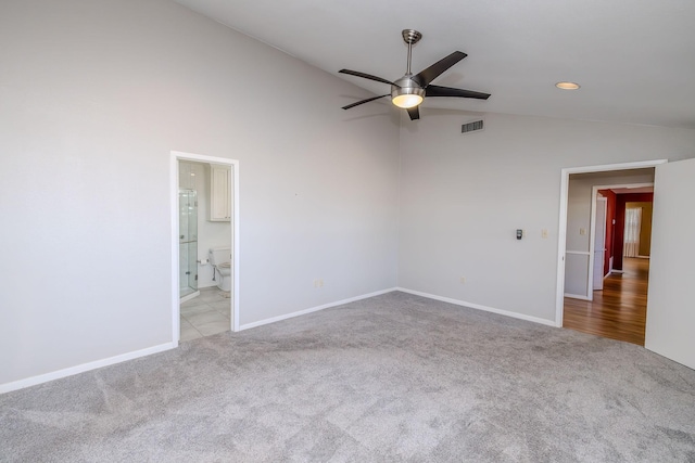 carpeted spare room featuring visible vents, lofted ceiling, baseboards, and a ceiling fan