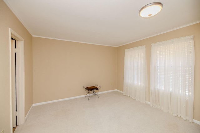 carpeted spare room with crown molding and baseboards