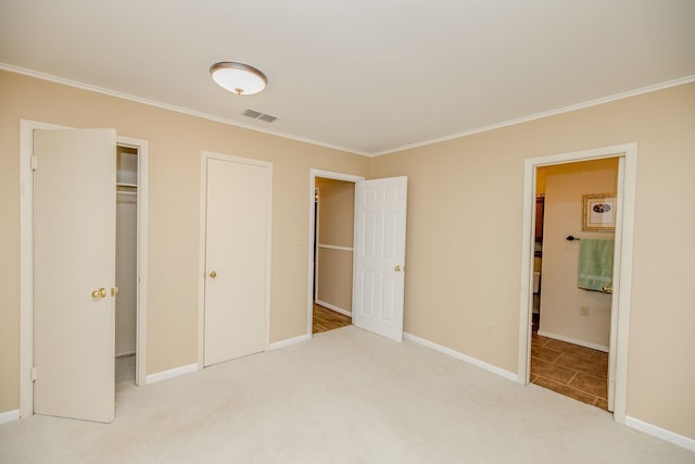 unfurnished bedroom with visible vents, crown molding, baseboards, and carpet floors