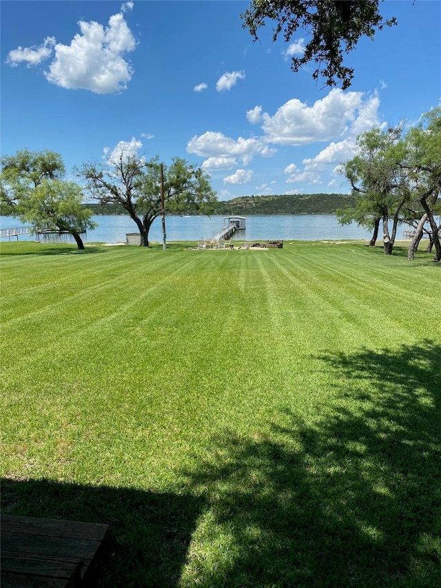 view of yard featuring a water view and a boat dock