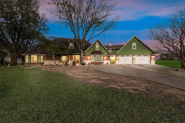 view of front of property with driveway, an attached garage, and a yard