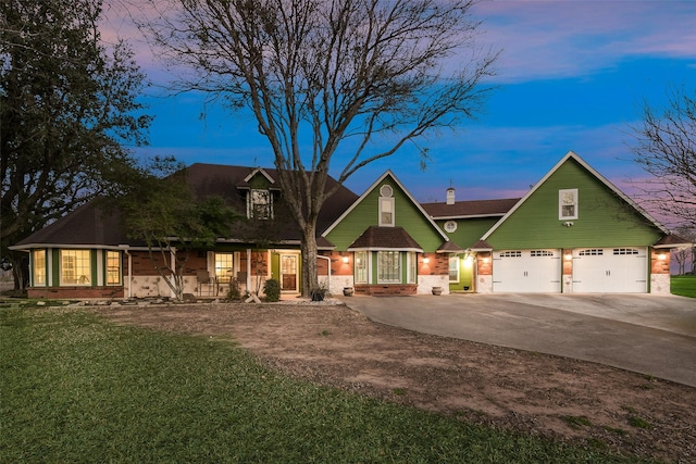 view of front of house featuring a front yard, brick siding, a garage, and driveway