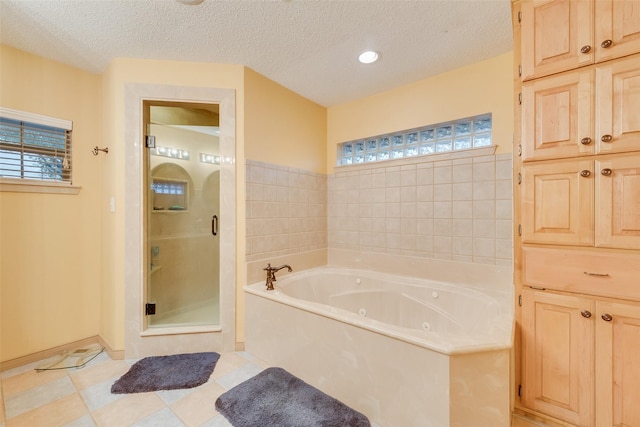 bathroom with a shower stall, a textured ceiling, baseboards, and a whirlpool tub