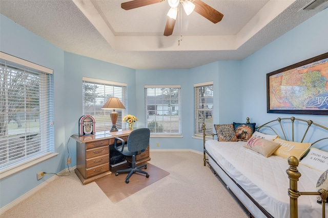 bedroom with visible vents, multiple windows, a textured ceiling, and a tray ceiling