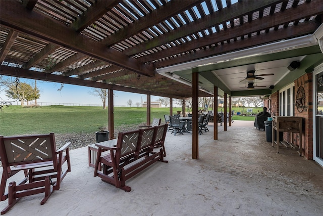 view of patio with outdoor dining area, ceiling fan, and a pergola