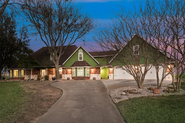 craftsman house with brick siding, driveway, and a front yard